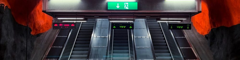 black and white escalator in a tunnel